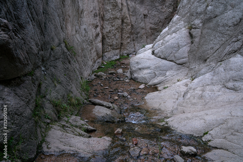 The hiking path and stream flowing across the rocky canyon. The hiking path and stream flowing across the rocky canyon.