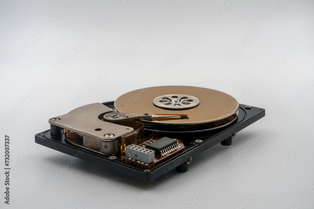 Hard disk drive (HDD), circular magnetic disk, platters. Central spindle, actuator arm with read write head, circuit board. Precision device for data storage, mechanical and electronic components Hard disk drive (HDD), circular magnetic disk, platters. Central spindle, actuator arm with read write head, circuit board. Precision device for data storage, mechanical and electronic components