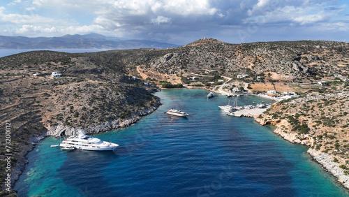 Aerial drone photo of small port of Schoinousa island a safe harbour to yachts and sail boats featuring small beach of Myrsini covered in Almirikia trees, Small Cyclades, Greece