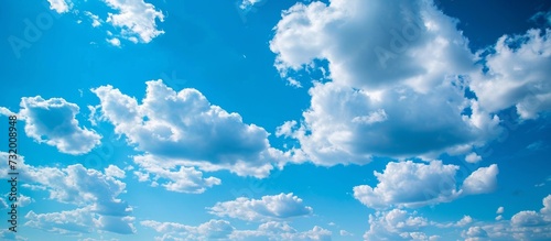 The azure sky adorned with fluffy cumulus clouds creates a breathtaking natural landscape.