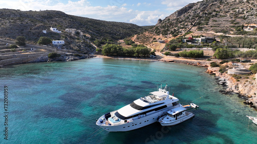 Aerial drone photo of small port of Schoinousa island a safe harbour to yachts and sail boats featuring small beach of Myrsini covered in Almirikia trees, Small Cyclades, Greece photo