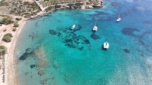 Aerial drone photo from tropical exotic paradise secluded rocky island bay with deep turquoise and sapphire sea forming a blue lagoon visited by yachts and sail boats in Caribbean exotic destination