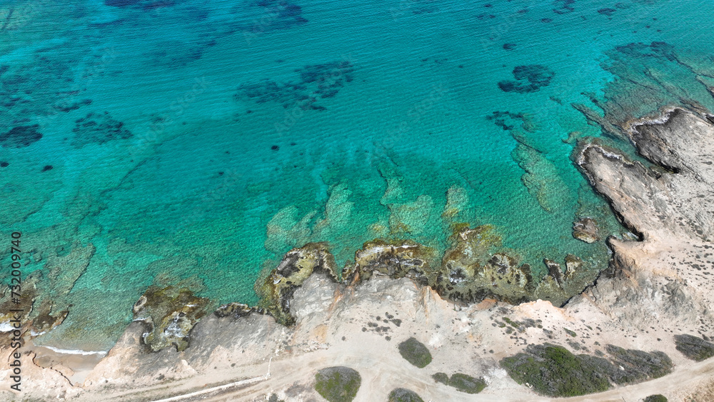 Fototapeta premium Aerial drone photo from tropical exotic paradise secluded rocky island bay with deep turquoise and sapphire sea forming a blue lagoon visited by yachts and sail boats in Caribbean exotic destination