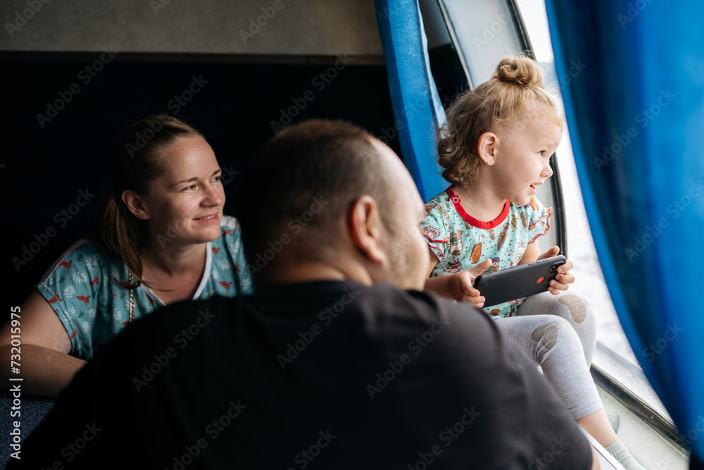 Child Engrossed in Mobile Game with Parents on Ferry Ride Child Engrossed in Mobile Game with Parents on Ferry Ride