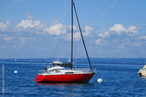 Eye-catching red and white boat sailing peacefully across a serene blue body of water