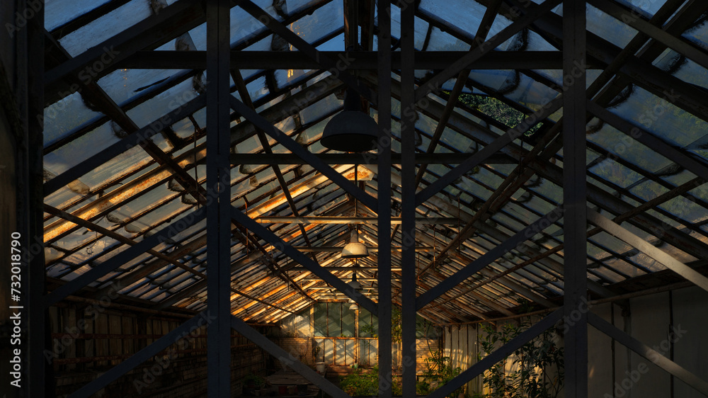 Old abandoned greenhouse at sunset.