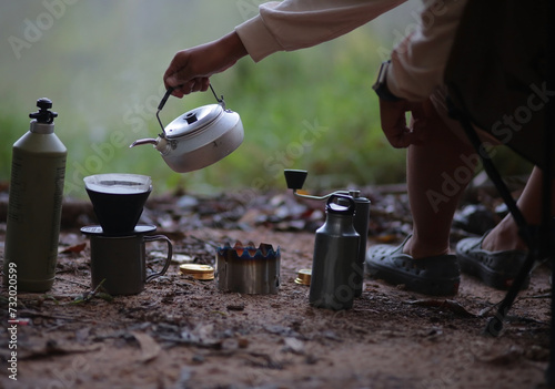 A man making drip coffee at the campsite .preparing coffee on a tented camp. selective focus