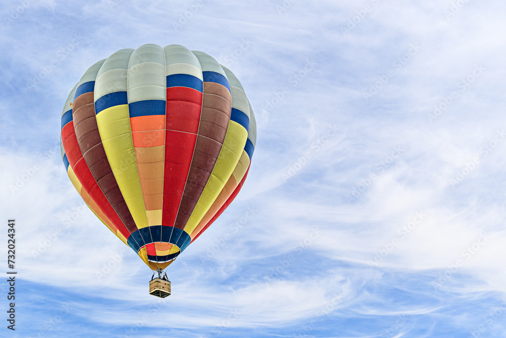 Naklejka premium Colorful hot air balloon flying over blue sky with white clouds 