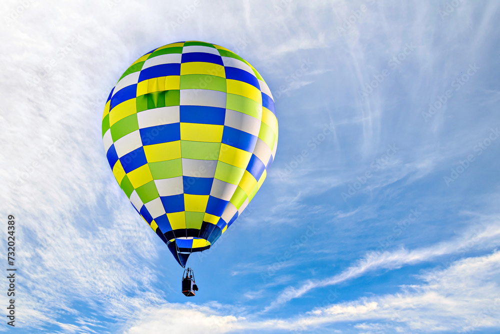 Fototapeta premium Colorful hot air balloon flying over blue sky with white clouds 