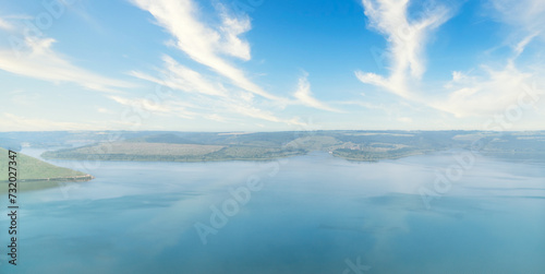 Serene lake view with clear blue skies and fluffy clouds. Beauty of nature. Copy space background.
