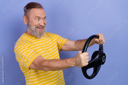 Profile photo of handsome positive person hands hold wheel look empty space isolated on violet color background