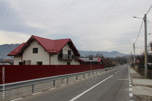 Fototapeta Naklejka Na Ścianę i Meble -  A road with a building and mountains in the background