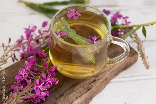 A drink (decoction) from the leaves and flowers of the medicinal plant ivan-tea (cypress, epilobium) in a mug. Traditional medicine, collection of useful herbs. Alternative medicine