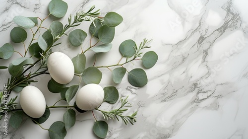 branches of eucalyptus decorated with eggs and green leaves on white marble