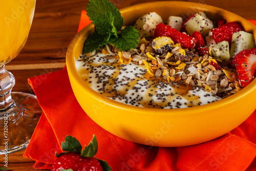 bowl with natural yogurt, granola, fruit, chia and honey