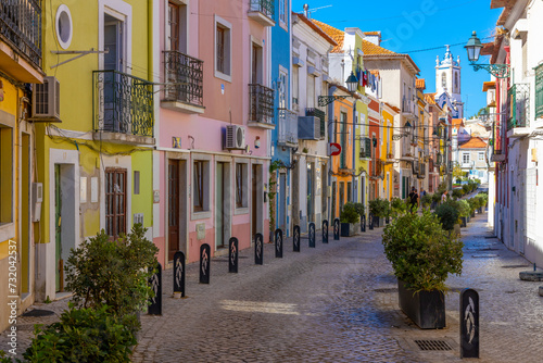 Setubal, Portugal. 16 August 2023. Colorful old houses in a European street, narrow with its ancient buildings, European city. A cityscape of Setúbal with a white church in the distance. photo