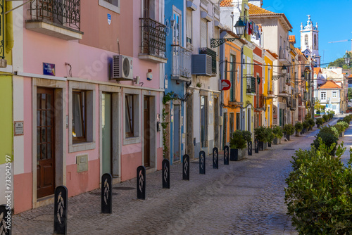 Setubal, Portugal. 16 August 2023. Colorful old houses in a European street, narrow with its ancient buildings, European city. A cityscape of Setúbal with a white church in the distance.