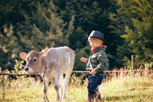Little Toddler Cowboy Kid with Little Cute Calf the Cow