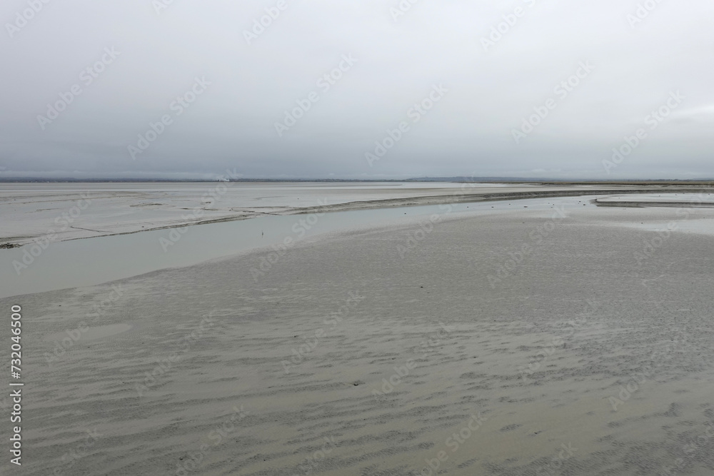 Baie du Mont-Saint-Michel à marée basse sous la brume Baie du Mont-Saint-Michel à marée basse sous la brume