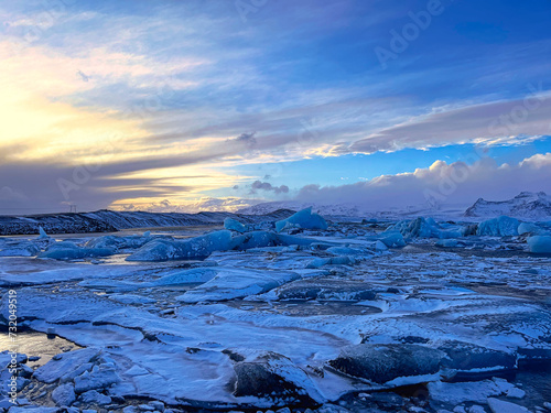 Icebergs swimming at the famous glacier lagoon around Vatnajokull National Park during winter around sunset time 