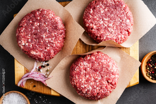 Burger steak cutlets on parchment paper, high angle view photo