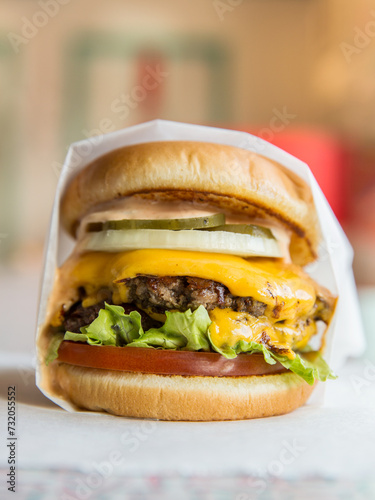 Beef cheeseburger with wrapper.