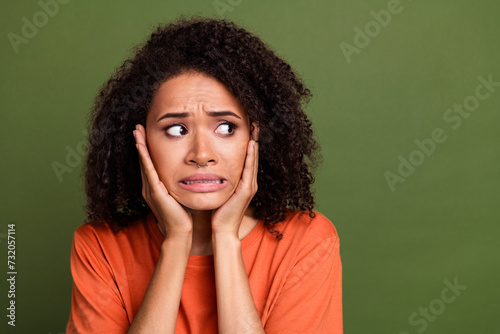Photo portrait of attractive young woman frightened look empty space dressed stylish orange clothes isolated on khaki color background © deagreez