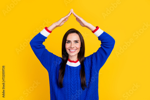 Portrait photo of mature age woman make arms roof gesture above head decided to create her own house isolated on yellow color background © deagreez