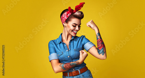 Strong Hispanic woman with red bandana dressed as Rosie the Riveter, flexing muscles and laughing photo
