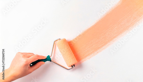 A hand draws a straight line with a roller brush with peach paint on a neutral white background. Banner design concept. copy space. Foam Roller, Brush for Painting.
