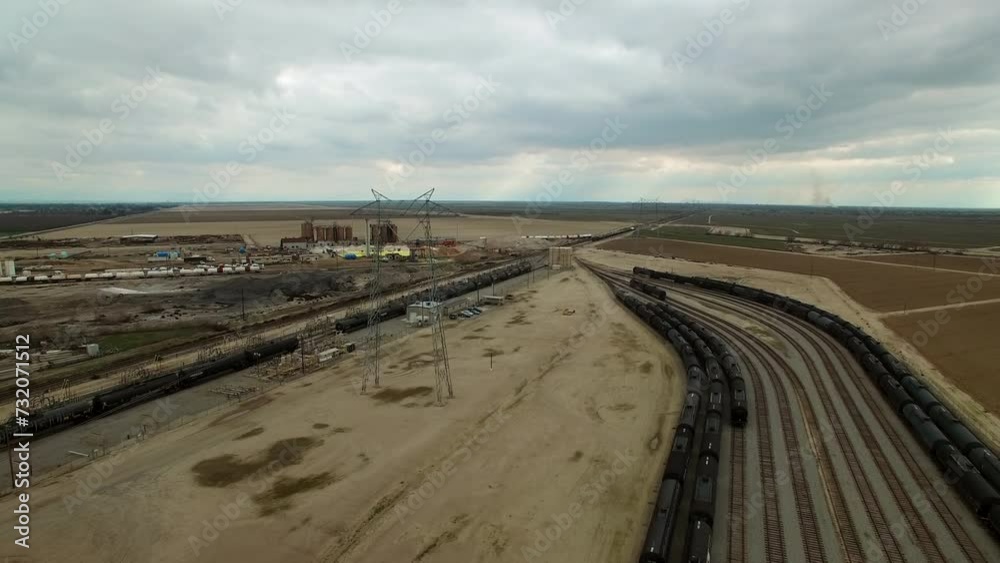 Aerial Forward Shot Of Transmission Tower By Tranquil Shunting Yard Under Cloudy Sky - Bakersfield, California Aerial Forward Shot Of Transmission Tower By Tranquil Shunting Yard Under Cloudy Sky - Bakersfield, California