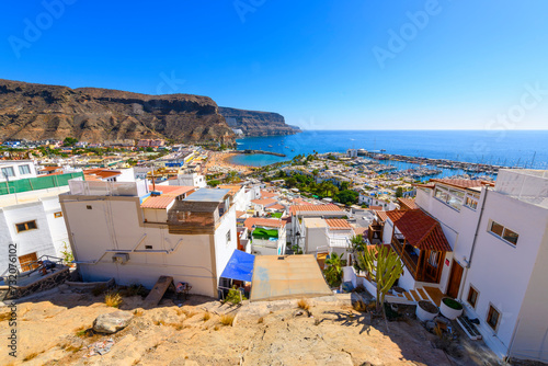 Scenic panoramic view from the lookout viewpoint of the bay, beach, harbor, mountains and village of Puerto de Mogan, Las Palmas, Spain, Gran Canaria, Canary Islands.	 photo