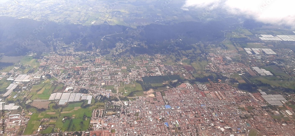 Aerial View of the City of Medellin prior to landing. Surrounded by Mountains, many Buildings, Houses, Trees in a Beautiful Landscape