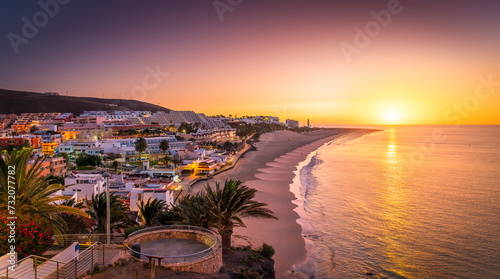 Bask in the warm glow of sunset at Morro Jable, Fuerteventura, where golden sands meet tranquil Atlantic waters—a photographer dream photo