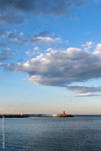 Seascape with big white clouds on the horizon in the late afternoon