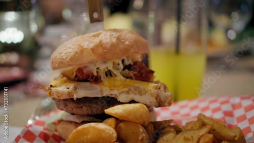 Tasty homemade hamburger in a small american restaurant, unhealthy fast food, egg barbecue burger meal, cinematic slow motion video