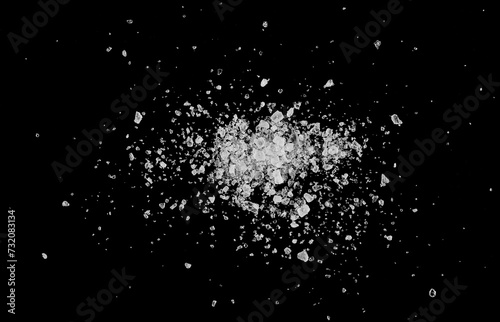 Close up sea ​​salt grains, crystals scattered isolated on black background, top view, macro 