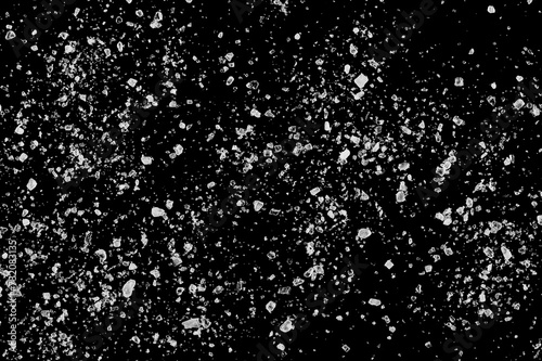Macro sea ​​salt grains, crystals scattered isolated on black, texture