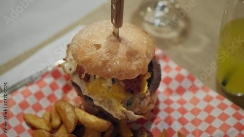 4K shot of a tasty homemade hamburger in a small american restaurant, unhealthy fast food, egg barbecue burger meal, cinematic slow motion video