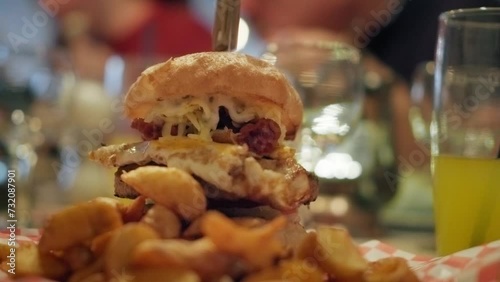 4K shot of a tasty homemade hamburger in a small american restaurant, unhealthy fast food, egg barbecue burger meal, cinematic slow motion video