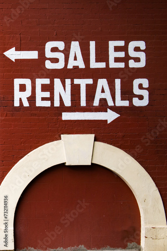 A sign saying sales to the left and rentals to the right on the side of an outdoor gear outfitter photo