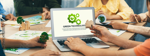 Green technology logo displayed on green business laptop while business team presenting green design to customer. ESG environment social governance and Eco conservative concept. Closeup. Delineation photo