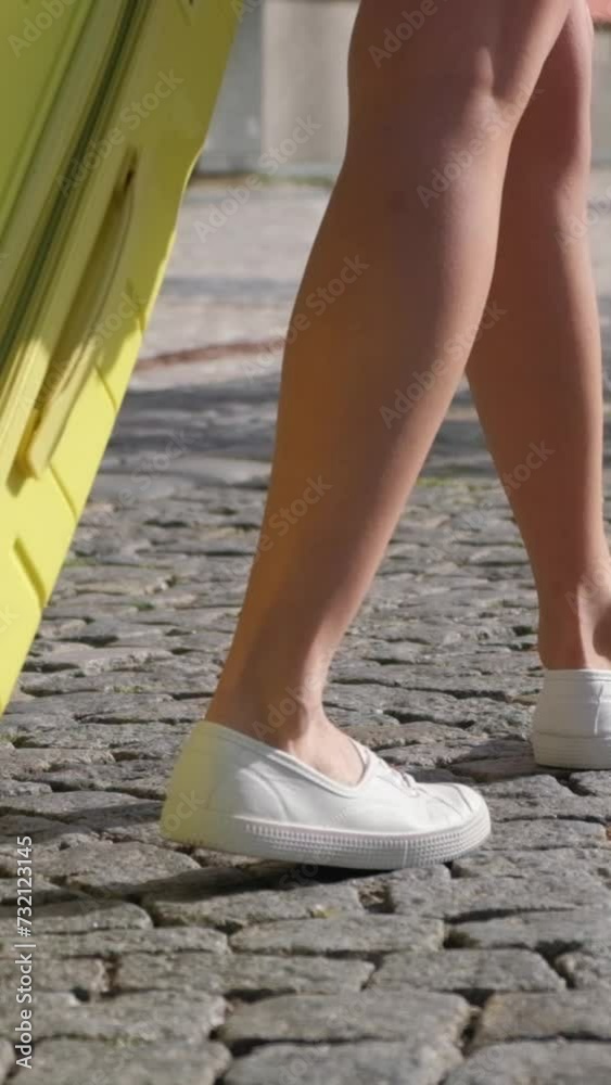 A woman with a suitcase is heading to the hotel. Travel and tourism concept. Vertical video A woman with a suitcase is heading to the hotel. Travel and tourism concept. Vertical video