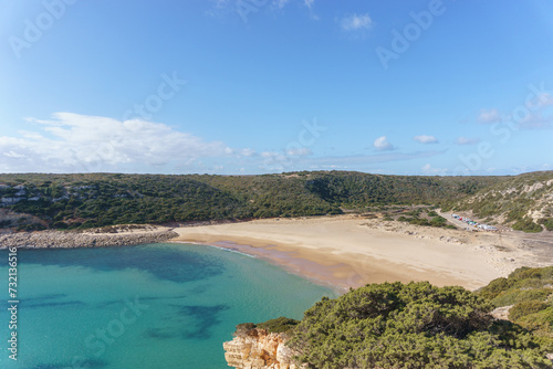 View over the beach of Praia do Barranco with clear turquoise water and a blue sky, Sagres, Algarve, Portugal