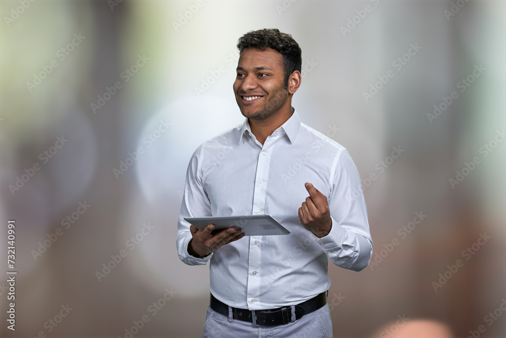 Obraz premium Successful indian businessman giving presentation to business partners. Abstract bokeh background. People, business, technology and lifestyle concept.