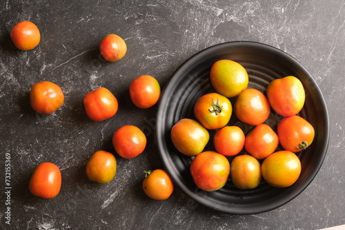 Tomatoes or rangam are plants from the Solanaceae family, plants native to Central and South America, from Mexico to Peru. tomatoes in a black plate. Solanum lycopersicum