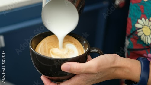 closeup hand doing hot latte art coffee
