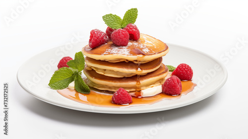 Decadent Fresh Delicious And Scrumptious Stack of Pancakes Garnished With Fresh Raspberries, Mint Leaves and Drizzled With Maple Syrup