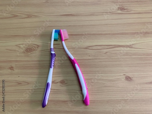 toothbrush on the table  Two toothbrushes pink and purple lying on a wooden surface