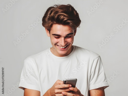 A caucasian boy in his 20s smiling with a smart phone